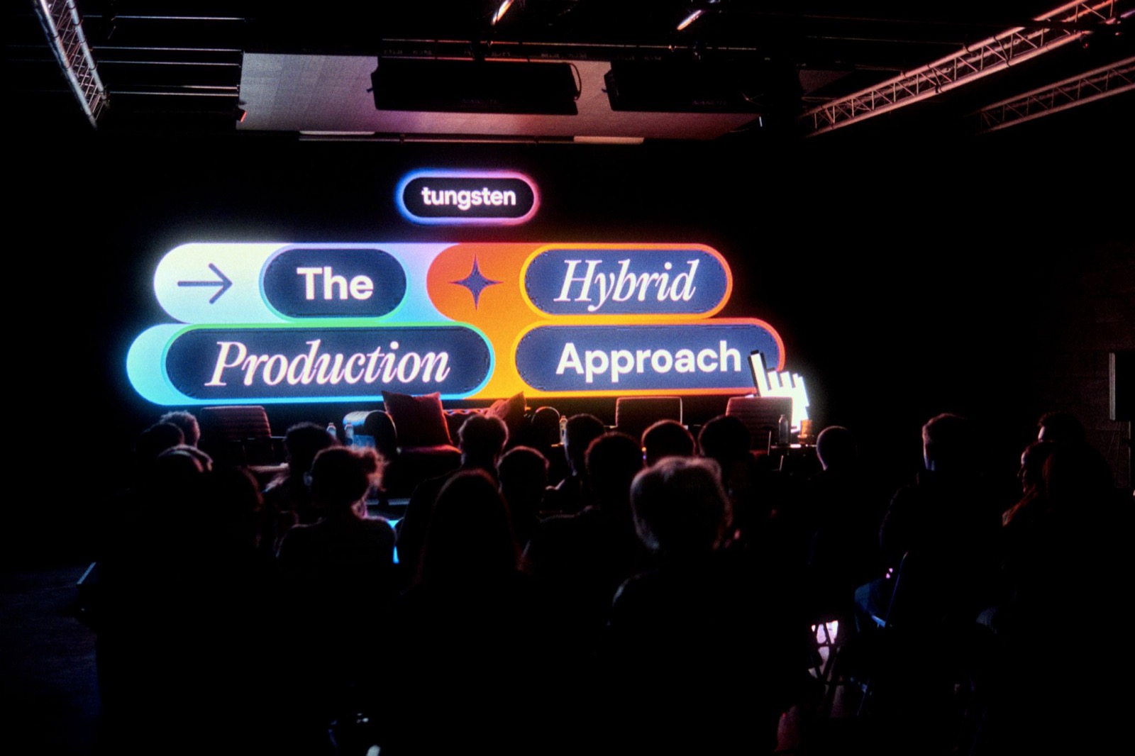 The Hybrid Production Approach neon title on the studio wall, 2025